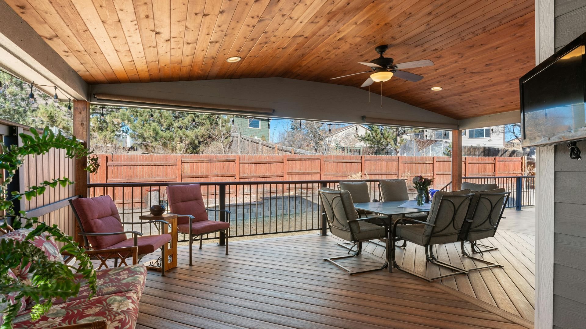 Covered wooden deck with patio furniture, dining set, and wooden ceiling